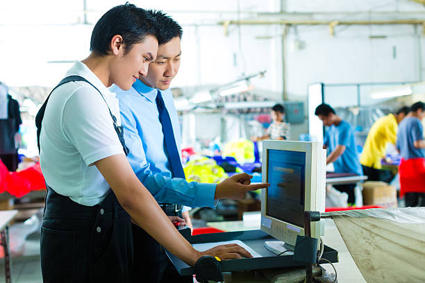 Worker is new assigned to a machine in a textile factory, the foreman explains something